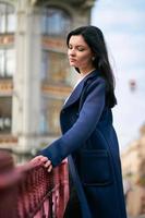 ritratto primo piano di bella bruna intelligente che cammina per strada di st. pietroburgo nel centro della città. affascinante donna premurosa con lunghi capelli scuri vaga da sola, immersa nei pensieri foto