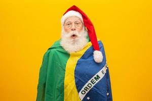 Babbo Natale è un fan del Brasile. tifoso di babbo natale della squadra brasiliana. campionato sportivo. Babbo Natale che tiene la bandiera brasiliana. partita di calcio. foto