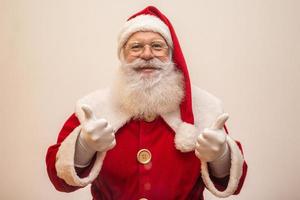 Babbo Natale su sfondo bianco con spazio di copia. pollice in su. foto