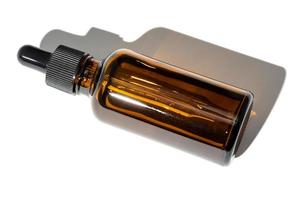 bottiglia di olio essenziale ambrata con pipetta isolata su sfondo bianco foto