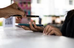 vista ravvicinata della mano di un uomo che esegue la scansione di un codice QR con un telefono cellulare per pagare. foto