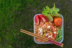 papaia ed erba vegetale tritate in una scatola sul pavimento. foto