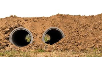 entrambi i tubi di cemento sono sepolti nel terreno. foto