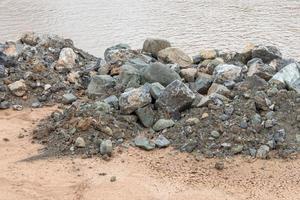 mucchio di granito a terra vicino alla riva del fiume. foto