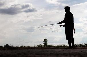 silhouette uomini tailandesi in piedi di pesca. foto