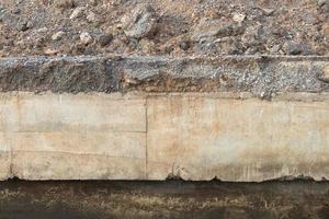 cemento sotto l'erosione della strada di ghiaia in pietra. foto