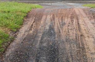 strada sterrata bagnata con tracce di ruote di auto. foto