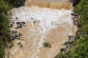 l'acqua selvaggia scorre con forza dalla diga traboccante. foto