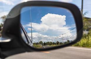 nuvole di cielo dagli specchietti laterali dell'auto durante il giorno in campagna. foto