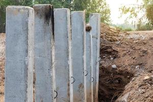 molti pali di cemento nel terreno scavato per la costruzione. foto