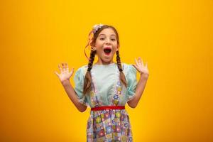 bambino in abiti tipici della famosa festa brasiliana chiamata festa junina nella celebrazione di sao joao. bella ragazza su sfondo giallo. foto