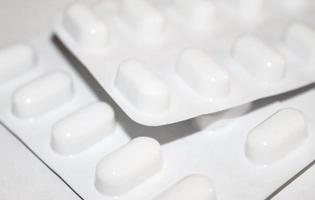 concetto di farmacia farmacia. confezioni di pillole bianche confezionate in blister con spazio per la copia isolato su uno sfondo bianco. concentrarsi sul primo piano, bokeh morbido. foto
