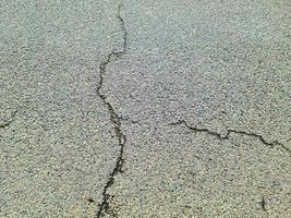 superfici di asfalto di strade danneggiate e strade con crepe in primo piano. foto