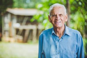 ritratto di sorridente bellissimo agricoltore maschio più anziano. uomo anziano in fattoria in un giorno d'estate. attività di giardinaggio. uomo anziano brasiliano. foto