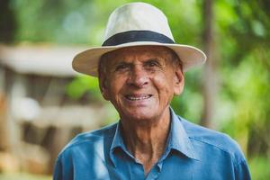 ritratto di sorridente bellissimo agricoltore maschio più anziano. uomo anziano in fattoria in un giorno d'estate. attività di giardinaggio. uomo anziano brasiliano. foto