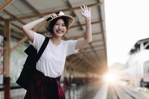 donna giovane viaggiatore in cerca di un viaggio di pianificazione amico alla stazione ferroviaria. concetto di stile di vita estivo e di viaggio foto