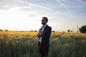 l'uomo in tuta si rilassa e medita nei campi durante il bel tramonto foto