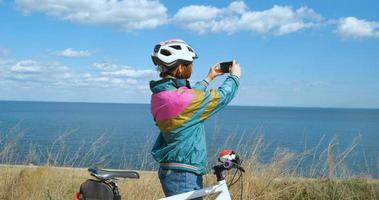 giovane donna ciclista in casco in una soleggiata giornata estiva foto