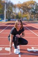 giovane corridore femminile che si allena in una giornata estiva all'aperto sullo studium foto