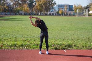 giovane corridore femminile che si allena in una giornata estiva all'aperto sullo studium foto