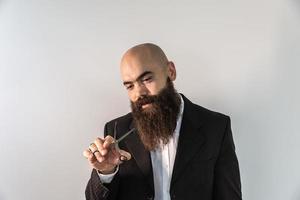 barbiere con la barba lunga usando le forbici foto
