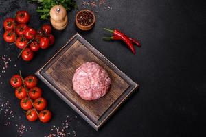 carne macinata con ingredienti per cucinare su sfondo nero foto