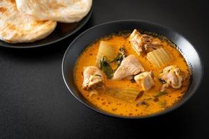 zuppa di pollo al curry con roti foto