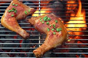 due gustosi quarti di pollo sulla griglia calda del barbecue foto