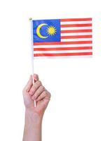 mano che tiene la bandiera della Malesia, isolata su sfondo bianco foto