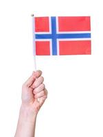 una mano tiene la bandiera della Norvegia su uno sfondo bianco isolato. foto