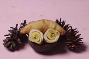 banane al cioccolato da materie prime ricoperte da rotoli di sfoglia. le banane molen con pasticcini vengono solitamente servite con una tazza di caffè o tè caldo. sfocatura della messa a fuoco foto