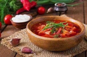 tradizionale borscht vegetale russo ucraino sullo sfondo di legno vecchio foto