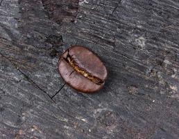 chicco di caffè su fondo in legno (legna che brucia) foto