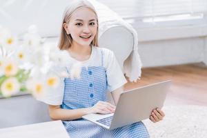 giovane ragazza asiatica che utilizza il computer portatile a casa foto