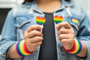 la signora asiatica con il cuore della bandiera arcobaleno, simbolo del mese dell'orgoglio lgbt, celebra l'annuale a giugno sociale di gay, lesbiche, bisessuali, transgender, diritti umani. foto