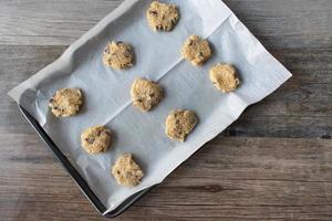 biscotti crudi di farina d'avena fatti in casa non cotti su una teglia piatta foto