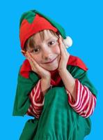 ragazzo felice sorridente vestito da elfo di natale su sfondo blu foto