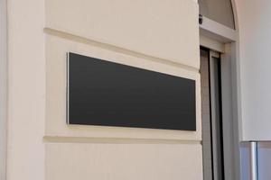 cartello nero all'ingresso del palazzo della società. superficie pulita per la presentazione del logo aziendale foto