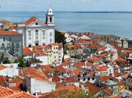 vista dall'alto tetti storici rossi edifici bianchi e fiume tago della città di lisbona portogallo foto