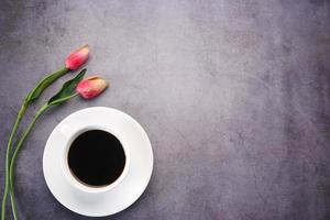 composizione piatta caffè, fiore di tulipano su sfondo nero. foto