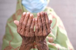 donne anziane con la mano della maschera facciale che pregano al ramadan foto