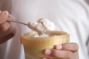 mangiare il gelato al cioccolato e vaniglia in un contenitore foto