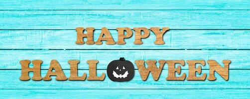 parola halloween fatta di lettere di legno su sfondo blu muro di legno. foto