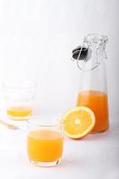 bicchiere di succo d'arancia e una bottiglia di succo d'arancia foto