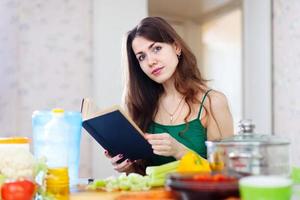la bella donna legge il libro di cucina per la ricetta foto