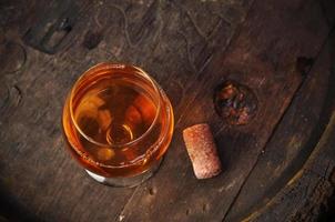 bicchiere di cognac sulla botte di legno vintage