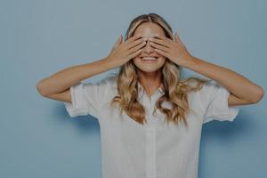 ragazza bionda che si copre gli occhi con le mani foto