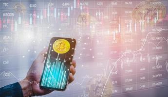 smartphone con grafico bitcoin sullo schermo tra pile di concetto bitcoin. tocco dell'uomo d'affari sullo schermo dell'app mobile con grandi pulsanti di acquisto e vendita. bitcoin sul mercato azionario, criptovaluta e finanza. foto