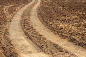 tracce di ruote su terreni di agricoltura rurale. foto