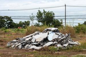 detriti detriti, muro di mattoni vicino al recinto di cemento. foto